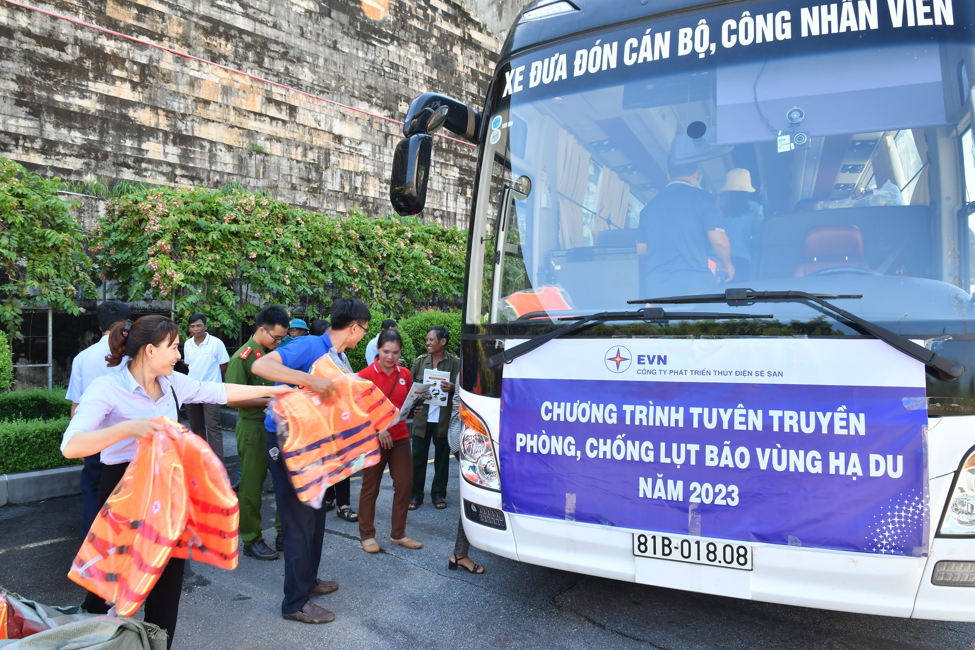 A group of people standing next to a busDescription automatically generated