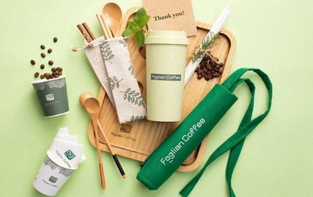 A coffee cup and spoons on a wooden trayDescription automatically generated